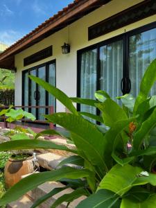 una casa con grandes plantas verdes delante de ella en Villas Chaba, en Thong Nai Pan Yai