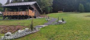 uma casa com um deque e escadas num campo em Chalet neuf avec jacuzzi privé, vue imprenable sur Massif des Vosges em Belfahy