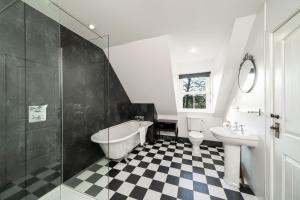 a bathroom with a tub and a toilet and a sink at Thatched Cottage in Broughty Ferry