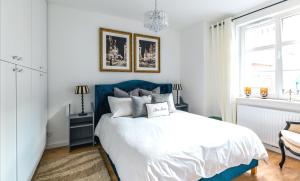 Un dormitorio con una cama azul y blanca y una ventana en Bea Home Elblag - dwie sypialnie en Elblag