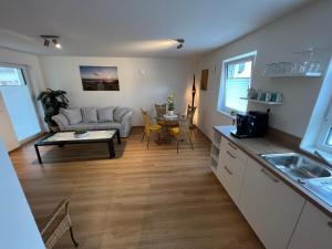 a kitchen and living room with a couch and a table at Apartment am Kirchplatz in Appenweier