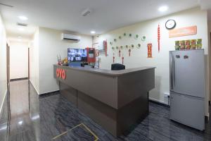 a restaurant with a counter and a refrigerator at OYO 90380 Hotel Jasin in Jasin