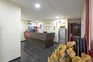 a waiting room with a counter and a refrigerator at OYO 90380 Hotel Jasin in Jasin