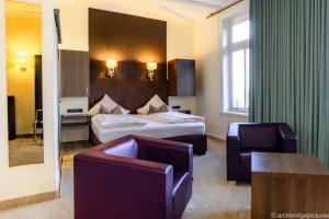 Bad RehburgにあるParkhotel Bad Rehburgのベッド2台と椅子があるホテルの部屋 +27枚の写真