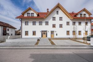 a large white house with a red roof at Ferienwohnung Rosa in Gilching