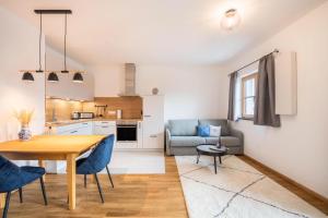cocina y sala de estar con mesa y sillas en Ferienwohnung Max, en Gilching