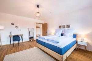 a bedroom with a blue bed and a desk at Ferienwohnung Max in Gilching