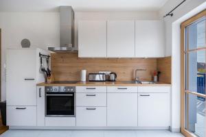 a kitchen with white cabinets and a sink at Ferienwohnung Maria in Gilching