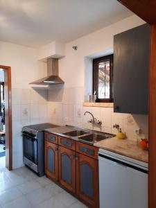 una cucina con lavello e fornello di Casa d'Avo - Cascais-Estoril a São Domingos de Rana