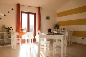 una sala da pranzo con tavolo e sedie bianchi di L&B bed and breakfast a Terranova di Pollino