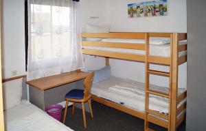 Schlafsaal mit Etagenbetten, einem Schreibtisch und einem Stuhl in der Unterkunft Ferienhaus Nr 3, Typ A, Feriendorf Hochbergle, Allgäu in Bichel