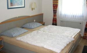 Un dormitorio con una cama grande y una ventana en Ferienhaus Nr 6, Kategorie Königscard, Feriendorf Hochbergle, Allgäu, en Bichel