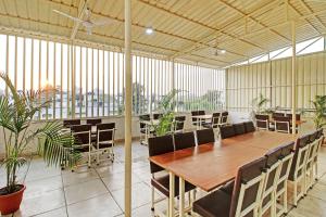 a large room with a table and chairs and plants at Treebo Trend Krishna Regency ISBT Bus Stop in Bhopal