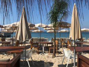 a group of tables and umbrellas on the beach at Les Petits Volets 3 appartements au choix in Antibes
