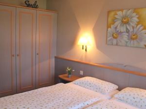 1 dormitorio con 2 camas y una foto de flores en la pared en Ferienhaus Nr 55, Kategorie Komfort, Feriendorf Hochbergle, Allgäu, en Karlsebene