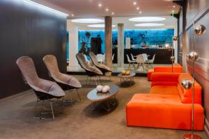 a living room with an orange couch and chairs at Rochester Hotel Classic in Buenos Aires