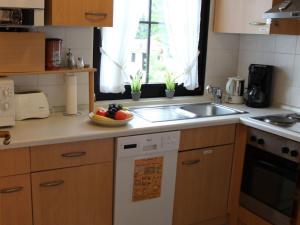 a kitchen with a sink and a bowl of fruit on the counter at Ferienhaus Nr 59, Kategorie Komfort, Feriendorf Hochbergle, Allgäu in Karlsebene