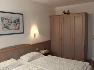 um pequeno quarto com uma cama e um armário em Ferienhaus Nr 59, Kategorie Komfort, Feriendorf Hochbergle, Allgäu em Karlsebene