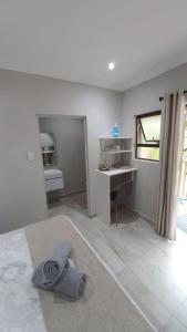 a bedroom with a bed and a desk and a window at Guest house on Gillian Unit 4 in Ballito