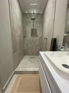 La salle de bains est pourvue d'un lavabo blanc et d'une douche. dans l'établissement Guest house on Gillian Unit 4, à Ballito