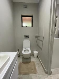 a bathroom with a white toilet and a sink at Guest house on Gillian Unit 4 in Ballito