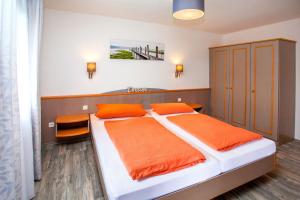 a bedroom with a large bed with orange sheets at Ferienhaus Nr 49, Kategorie Premium, Feriendorf Hochbergle, Allgäu in Karlsebene