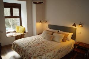 1 dormitorio con cama con almohadas y ventana en Molino Mellado en Casavieja