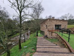 un viejo edificio de piedra en una colina al lado de un campo en Molino Mellado en Casavieja