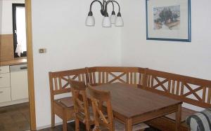 cocina con mesa de comedor de madera y sillas en Ferienhaus Nr 18, Kategorie Komfort, Feriendorf Hochbergle, Allgäu, en Bichel