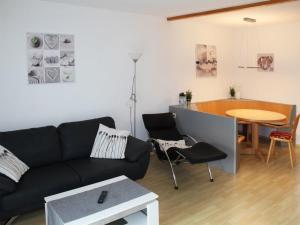 Karlsebene的住宿－Ferienhaus Nr 50, Kategorie Premium, Feriendorf Hochbergle, Allgäu，客厅配有沙发和桌子