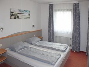 Karlsebene的住宿－Ferienhaus Nr 50, Kategorie Premium, Feriendorf Hochbergle, Allgäu，一间卧室设有两张床和窗户。