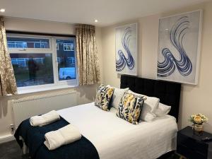 a bedroom with a bed with pillows and a window at FW Haute Apartments at Stanmore, 3 Bedrooms and 1 Bathroom with additional WC, Single or Double Beds, Pet-Friendly Flat with FREE WIFI and PARKING in Stanmore