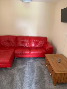 a red couch in a room with a coffee table at Morrison Close in Newton Aycliffe