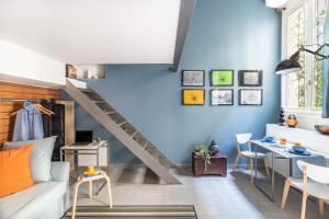 a living room with blue walls and a staircase at ALTIDO Vibrant Studio for 3 near the City Centre in Milan