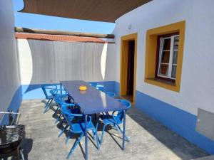 a blue table and chairs in a room at Casa do Páteo in Vila Nova da Baronia