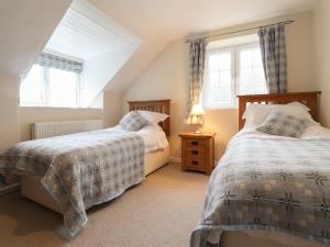 a attic bedroom with two beds and two windows at Step in in Fishguard