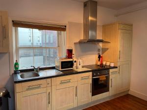 uma cozinha com um micro-ondas e um lavatório em Wall St flat by HNFC Stays - Netflix & Popcorn em Newcastle upon Tyne