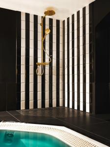 a bathroom with a tub and a black and white wall at Dandy Hotel in Paris