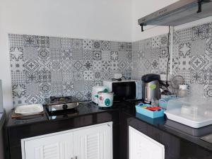 una cucina con piano di lavoro nero e forno a microonde di SuanMalisamuiVilla G02 a Ko Samui
