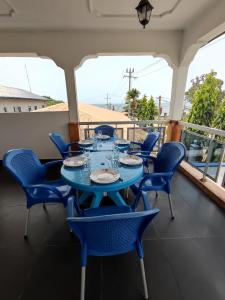 a blue table and chairs on a balcony at Maison MIDAREA in Kribi