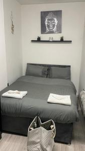a bedroom with a bed with a headboard and a bag at BvApartments Queensgate 1 in Huddersfield