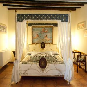 a bedroom with a canopy bed with a painting on the wall at Hostal Santa Agueda in Tarazona de Aragón
