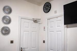 a clock on a wall next to a white door at BvApartments Queensgate 1 in Huddersfield
