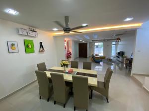 史里肯邦安的住宿－Entire Residential Home•Jia Residences Bkt Serdang沙登温暖的家，用餐室以及带桌椅的起居室。