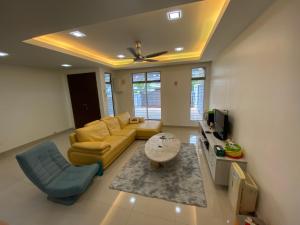 een woonkamer met een bank en een tafel bij Entire Residential Home•Jia Residences Bkt Serdang沙登温暖的家 in Seri Kembangan