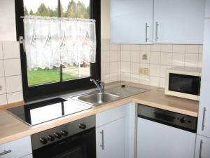 a kitchen with a sink and a window at Ferienhaus Nr 96, Kategorie Premium, Feriendorf Hochbergle, Allgäu in Karlsebene