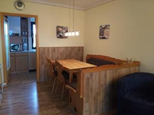 Il comprend une cuisine et une salle à manger avec une table et des chaises en bois. dans l'établissement Ferienhaus Nr 62, Kategorie Premium, Feriendorf Hochbergle, Allgäu, à Bichel