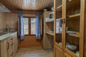 eine kleine Küche mit Holzschränken und einer Spüle in der Unterkunft Casas rurales El Arbol de la Vida in Riópar + 19 Fotos