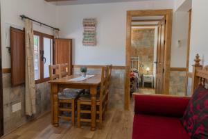 ein Esszimmer mit einem Holztisch und Stühlen in der Unterkunft Casas rurales El Arbol de la Vida in Riópar