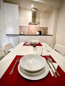 een tafel met witte borden en zilverwerk op een rood servet bij Apartamento Dama de noche in Córdoba